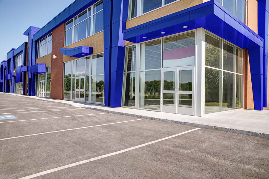 Business Insurance - View of an Empty Modern Commercial Office Building Ready for Lease with an Empty Parking Lot in Front